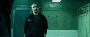 Movie still from “Max Payne” (2008), directed by John Moore – A man standing in front of a green wall; Close Up shot, Low angle