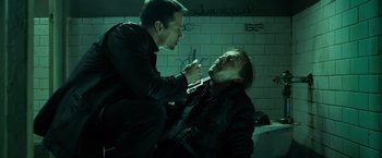 Movie still from “Max Payne” (2008), directed by John Moore – Two men in black shirts one of them is shaving another man's face; Medium shot, High angle