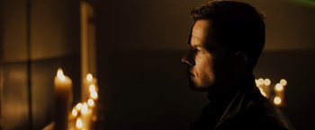 Movie still from “Max Payne” (2008), directed by John Moore – A person's face in the dark; Close Up shot, Over the shoulder angle