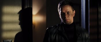 Movie still from “Max Payne” (2008), directed by John Moore – A man wearing a black jacket in a dark room; Close Up shot, Over the shoulder angle