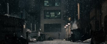 Movie still from “Max Payne” (2008), directed by John Moore – A person standing in front of a building in the snow; Extreme Wide shot, Low angle