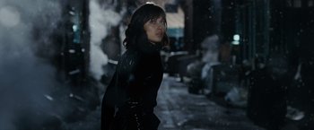 Movie still from “Max Payne” (2008), directed by John Moore – A woman standing in the middle of a street; Medium shot, Low angle