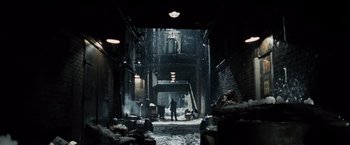 Movie still from “Max Payne” (2008), directed by John Moore – A man standing in the middle of an alleyway; Extreme Wide shot, Low angle