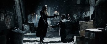 Movie still from “Max Payne” (2008), directed by John Moore – A man kneeling down on the ground to propose to a woman; Wide shot, High angle