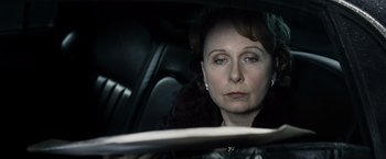 Movie still from “Max Payne” (2008), directed by John Moore – A woman sitting in the back seat of a car; Close Up shot, Over the shoulder angle