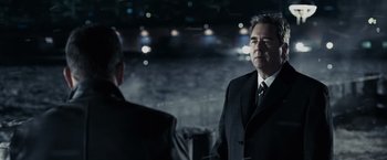 Movie still from “Max Payne” (2008), directed by John Moore – A man in a suit and tie standing next to another man in a suit and tie; Close Up shot, Over the shoulder angle