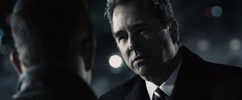 Movie still from “Max Payne” (2008), directed by John Moore – A person wearing a suit and tie; Close Up shot, Over the shoulder angle