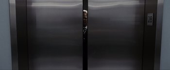 Movie still from “Max Payne” (2008), directed by John Moore – A man standing in front of an elevator door; Medium shot, Low angle