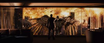 Movie still from “Max Payne” (2008), directed by John Moore – A man standing in front of an image of an angel; Wide shot, Low angle