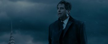 Movie still from “Max Payne” (2008), directed by John Moore – A man in a suit and tie standing in front of a cloudy sky; Close Up shot, Low angle