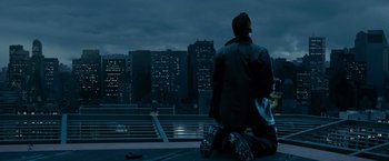 Movie still from “Max Payne” (2008), directed by John Moore – A man sitting on a bench looking at a city skyline at night; Wide shot, High angle
