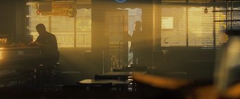 Movie still from “Max Payne” (2008), directed by John Moore – A person standing in front of a window in a room; Wide shot, Over the shoulder angle