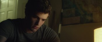 Movie still from “Max Steel” (2016), directed by Stewart Hendler – A young man sitting in the dark looking down at the floor; Close Up shot, Over the shoulder angle