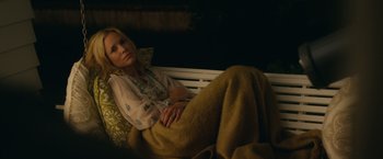 Movie still from “Max Steel” (2016), directed by Stewart Hendler – A woman laying on a bench with a blanket; Medium shot, High angle