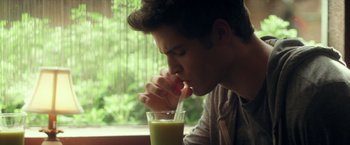 Movie still from “Max Steel” (2016), directed by Stewart Hendler – A young man drinking a glass of green juice; Close Up shot, Over the shoulder angle