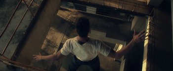 Movie still from “Max Steel” (2016), directed by Stewart Hendler – A man standing on the floor of a building; Wide shot, Overhead angle