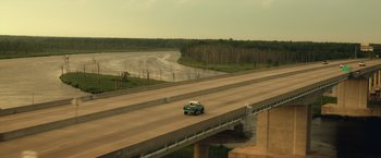 Movie still from “Max Steel” (2016), directed by Stewart Hendler – A car is driving on a bridge over a river; Extreme Wide shot, High angle