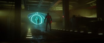 Movie still from “Max Steel” (2016), directed by Stewart Hendler – A man is standing in a tunnel with neon lights around him; Wide shot, Low angle