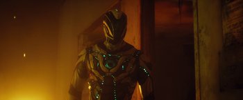 Movie still from “Max Steel” (2016), directed by Stewart Hendler – A man in a yellow and green costume with green lights; Medium shot, Low angle