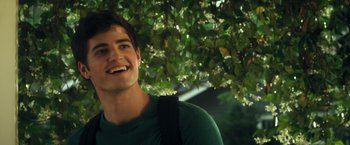 Movie still from “Max Steel” (2016), directed by Stewart Hendler – A young man smiles while standing next to a tree; Close Up shot, Over the shoulder angle