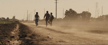 Movie still from “McFarland, USA” (2015), directed by Niki Caro – A group of young men running on a dirt road; Wide shot, Low angle