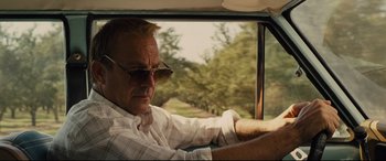 Movie still from “McFarland, USA” (2015), directed by Niki Caro – A man sitting in the driver's seat of a car; Close Up shot, Low angle