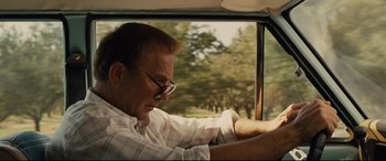 Movie still from “McFarland, USA” (2015), directed by Niki Caro – A man sitting in the driver's seat of a car; Close Up shot, Low angle