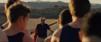 Movie still from “McFarland, USA” (2015), directed by Niki Caro – A man standing on the side of a road; Medium shot, Over the shoulder angle