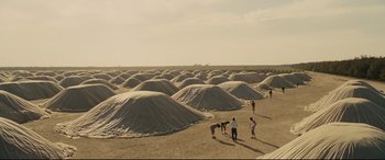 Movie still from “McFarland, USA” (2015), directed by Niki Caro – A group of people standing in the sand near a bunch of tents; Extreme Wide shot, High angle