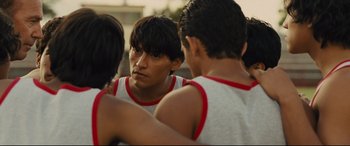 Movie still from “McFarland, USA” (2015), directed by Niki Caro – A group of young men standing next to each other on a field; Close Up shot, Over the shoulder angle