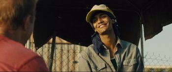 Movie still from “McFarland, USA” (2015), directed by Niki Caro – A young man wearing a hat and smiling for the camera; Close Up shot, Low angle