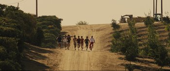 Movie still from “McFarland, USA” (2015), directed by Niki Caro – A group of young men running on a dirt road; Wide shot, Low angle