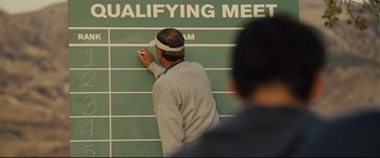 Movie still from “McFarland, USA” (2015), directed by Niki Caro – A man writing on a wall with a sharpie marker; Medium shot, Over the shoulder angle