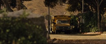 Movie still from “McFarland, USA” (2015), directed by Niki Caro – A school bus parked on the side of the road; Extreme Wide shot, High angle
