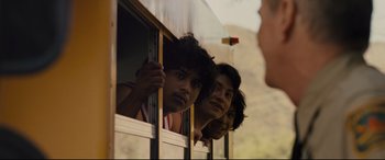 Movie still from “McFarland, USA” (2015), directed by Niki Caro – A group of young men looking out of a bus window; Medium shot, Over the shoulder angle