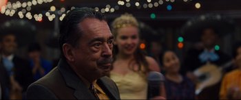 Movie still from “McFarland, USA” (2015), directed by Niki Caro – A man and a woman are standing in front of a microphone; Close Up shot, Over the shoulder angle