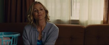 Movie still from “McFarland, USA” (2015), directed by Niki Caro – A woman sitting on a brown couch in a room; Close Up shot, Over the shoulder angle