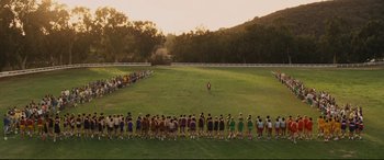 Movie still from “McFarland, USA” (2015), directed by Niki Caro – A large group of people standing in a grassy field; Extreme Wide shot, High angle