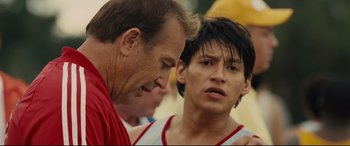Movie still from “McFarland, USA” (2015), directed by Niki Caro – Two men talking to each other while standing next to each other; Close Up shot, Over the shoulder angle