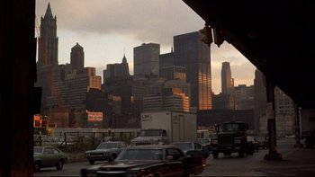 Movie still from “Mean Streets” (1973), directed by Martin Scorsese – A busy city street with cars driving down the road; Extreme Wide shot, Low angle
