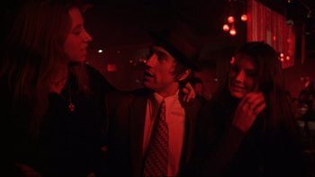Movie still from “Mean Streets” (1973), directed by Martin Scorsese – A group of young people in a dark room; Medium shot, Low angle