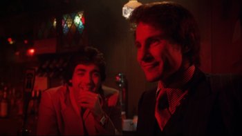 Movie still from “Mean Streets” (1973), directed by Martin Scorsese – Two men in suits are smiling for the camera; Close Up shot, Over the shoulder angle