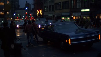 Movie still from “Mean Streets” (1973), directed by Martin Scorsese – A car is stopped at a red light on a busy city street; Wide shot, Over the shoulder angle