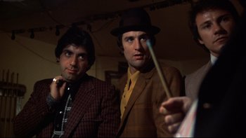 Movie still from “Mean Streets” (1973), directed by Martin Scorsese – Two men in suits and hats are posing for a picture; Medium shot, Low angle