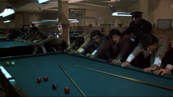 Movie still from “Mean Streets” (1973), directed by Martin Scorsese – A group of men playing a game of billiards; Wide shot, High angle