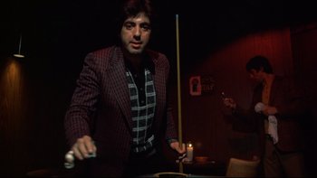 Movie still from “Mean Streets” (1973), directed by Martin Scorsese – A man standing in front of a pool table holding a nintendo wii game controller; Medium shot, Low angle