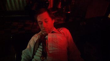 Movie still from “Mean Streets” (1973), directed by Martin Scorsese – A man in a white shirt and a red neck tie; Medium shot, High angle