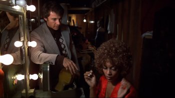 Movie still from “Mean Streets” (1973), directed by Martin Scorsese – A man and a woman are sitting in a room; Medium shot, Low angle