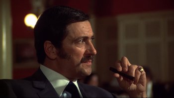 Movie still from “Mean Streets” (1973), directed by Martin Scorsese – A person wearing a suit and tie; Close Up shot, Low angle