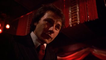 Movie still from “Mean Streets” (1973), directed by Martin Scorsese – A person wearing a suit and tie; Close Up shot, Low angle